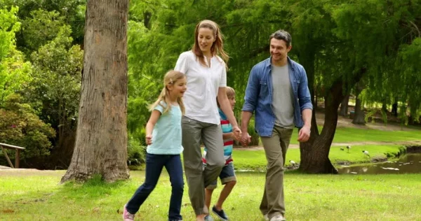 A family walking in the park, symbolizing a healthy and happy lifestyle.